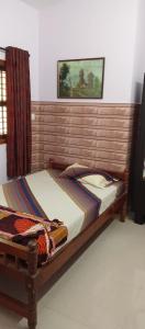 a bed with a wooden headboard in a bedroom at Lewis Paradise Homestay in Kalyānpur
