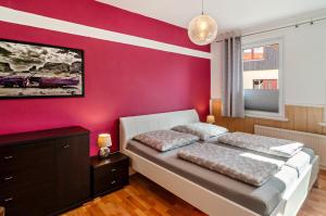 ein Schlafzimmer mit einer roten Akzentwand und einem Bett in der Unterkunft Ferienwohnung Gräfe in Herzberg am Harz