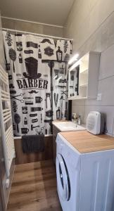 ein Badezimmer mit Waschbecken und Waschmaschine in der Unterkunft Ô Loue Rétro - 6 personne - 1er étage in Quingey