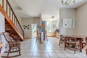 una cucina e una sala da pranzo con tavolo e sedie di Maison Les Marronniers a Montagne
