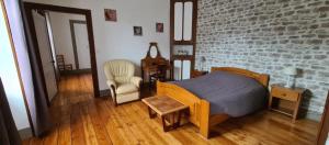 ein Schlafzimmer mit einem Bett und einer Ziegelwand in der Unterkunft Ô Loue Rétro - 6 personne - 1er étage in Quingey