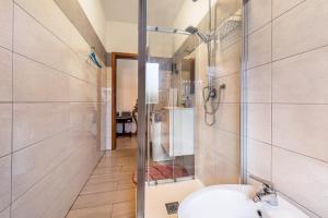a bathroom with a shower and a toilet and a sink at Luminoso appartamento in Bardolino +15 photos