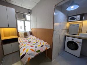 a small room with a bed and a washing machine at 利園賓館 in Hong Kong