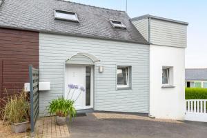 une maison grise avec une porte blanche dans l'établissement Maison de vacances proche de tout, à Quimper