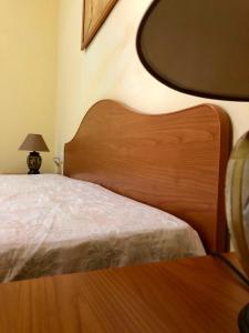 a bed with a wooden headboard in a room at Tiglio Vieste in Vieste
