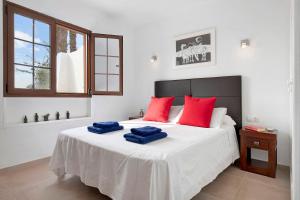 una camera da letto con un letto con cuscini rossi e blu di Puerto Chico M a Playa Blanca