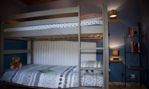 a bunk bed with a teddy bear sitting on the bottom bunk at Maison - Le Clos Des Pommiers in La Vicomté-sur-Rance