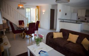a living room with a couch and a table at Maison - Le Clos Des Pommiers in La Vicomté-sur-Rance