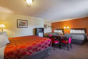 a hotel room with two beds and a table and chairs at Econo Lodge Hurricane Zion Park Area in Hurricane +19 photos