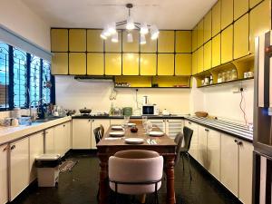 une cuisine avec des armoires jaunes, une table et des chaises dans l'établissement Cozy Homestay King Bed withBalcony in Shared Bungalow SS2 PJ, à Petaling Jaya 18 autres photos