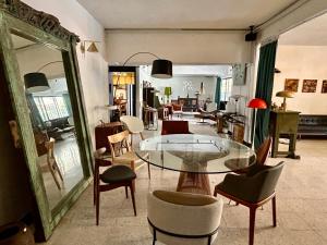 un salon avec une table en verre et des chaises dans l'établissement Cozy Family Homestay 2BR with Balcony in Shared Bungalow SS2 PJ, à Petaling Jaya