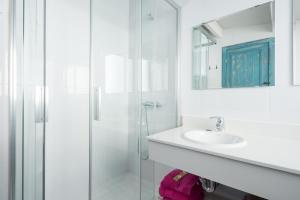 ein weißes Badezimmer mit Waschbecken und Dusche in der Unterkunft Blue Beach House ATICO CON TERRAZA in Málaga