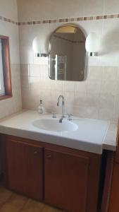 a bathroom with a white sink and a mirror at Villa Timao Plage in Batz-sur-Mer