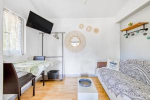 a living room with a couch and a tv at Studio Bleu Nature - Hourtin, Medoc in Hourtin