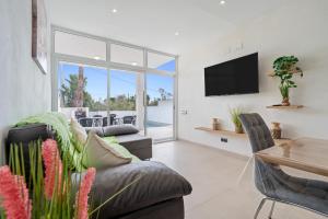 a living room with a couch and a tv and a table at Eucaliptus in Camarles