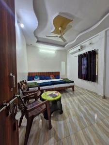 a room with a bed and a couch and a table at TARA Guest House in Ujjain +55 photos