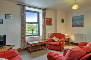 ein Wohnzimmer mit roten Stühlen und einem Fenster in der Unterkunft Finest Retreats - Old Nog Cottage, Stowford in Little Torrington