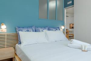 a bedroom with a large white bed with blue walls at Casa Bella in Golfo Aranci
