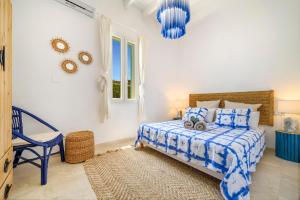 a bedroom with a blue and white bed and a chair at Can Torres in Pòrtol +27 photos