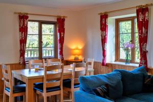 a dining room with a table and chairs and windows at Finest Retreats - Tarkas Holt Log Cabin, Stowford in Little Torrington