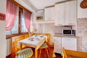 a small kitchen with a table and a microwave at Appartamento Privato Nelle Dolomiti in Vodo Cadore
