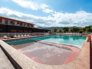 a large swimming pool with chairs and a building at Vacancéole - Les demeures de la Massane - Argelès-sur-Mer in Argelès-sur-Mer