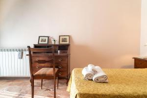 a bedroom with a bed and a dresser and a chair at Casa Dei Ricci in Lucca