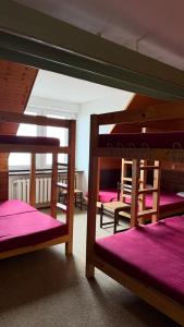 two bunk beds in a room with pink sheets at Výrovka in Pec pod Snezkou