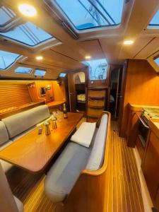 uma sala com um banco e uma mesa em um barco em Sailboat 39ft Sleep 6 in Heart of City Centre in Fredrikstad em Fredrikstad