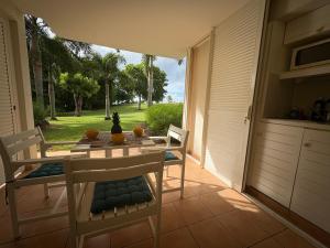 a dining room with a table and chairs on a patio at TI COCOTIER Studio PREMIUM Village Vacances in Sainte-Luce