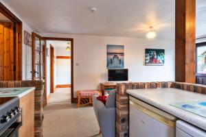 ein Wohnzimmer mit Couch und Küche in der Unterkunft Finest Retreat - Tarquol Cottage, Stowford in Little Torrington