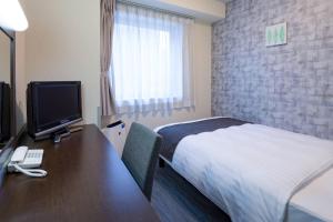 une chambre d'hôtel avec un lit et un bureau avec un ordinateur dans l'établissement Comfort Hotel Hakodate, à Hakodate