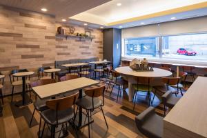 un restaurant avec des tables et des chaises et un bar dans l'établissement Comfort Hotel Hakodate, à Hakodate