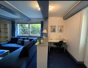 a living room with a blue couch and a desk at Wohnung Blume in Niederdorla