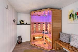 a large glass cabinet in a room with a bench at Ferienhaus Bella Vita in Walkenried