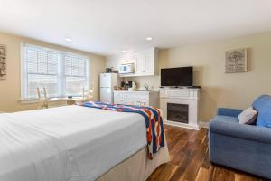 丹尼斯港Bluegreen Vacations The Breakers Resort, an Ascend Collection Resort的一间卧室，配有一张床、一把椅子和一台电视机