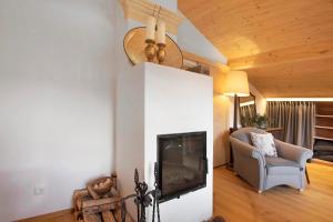 a living room with a fireplace and a chair at Haus Alpenveilchen - Appartement 4 in Schönau am Königssee