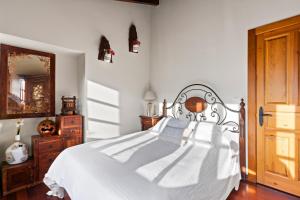 ein Schlafzimmer mit einem weißen Bett und einer Holztür in der Unterkunft La Casina Del Fresnu in Onón