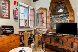 ein Wohnzimmer mit einem Flachbild-TV auf einer Holztruhe in der Unterkunft La Casina Del Fresnu in Onón