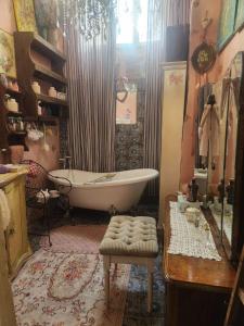 Un baño con bañera, silla y lavabo. en Tina's Art Home - Venetian Walls District, 