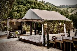 a pavilion with a wooden deck with a person standing on it at Nature Domes in Comboyne