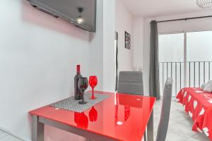 a red table with wine glasses on it in a bedroom at Nerja Boutique 204 Beauty in Nerja