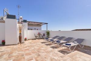 a patio with chairs and a table on a white wall at Nerja Boutique 204 Beauty in Nerja