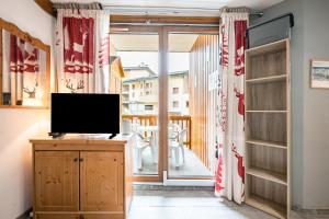 ein Wohnzimmer mit einem TV auf einer Holzkommode in der Unterkunft Au Refuge D'Hirka in Val Cenis