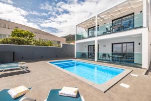 a swimming pool in the backyard of a house at Golden Home V in Caniçal