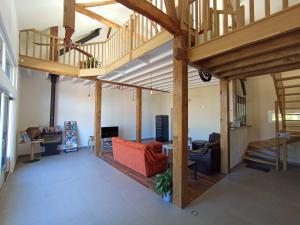 Elle comprend un salon doté de plafonds en bois et d'un canapé rouge. dans l'établissement Gite Bricabroc 4 personnes, à La Chapelle-aux-Choux