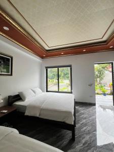 a bedroom with two beds and a large window at Tam Coc Mountain Light Homestay in Ninh Binh