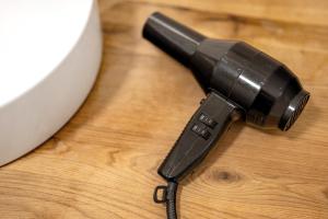 een haardroger bovenop een houten tafel bij Km Style Apartment Nr 1 in Freiburg im Breisgau