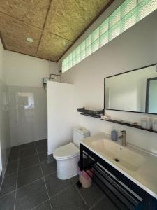 ein Badezimmer mit Waschbecken, Toilette und Spiegel in der Unterkunft ເຂົ້າໜຽວຟາມສະເຕ-Kao Niaw Farmstay in Luang Prabang