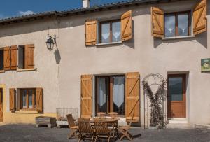 a table and chairs in front of a building at Maison - Chez Léontine in Espezel